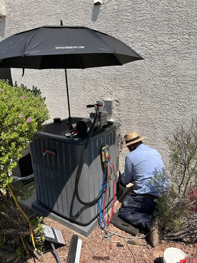 HVAC technician performing outdoor AC maintenance in Wilton